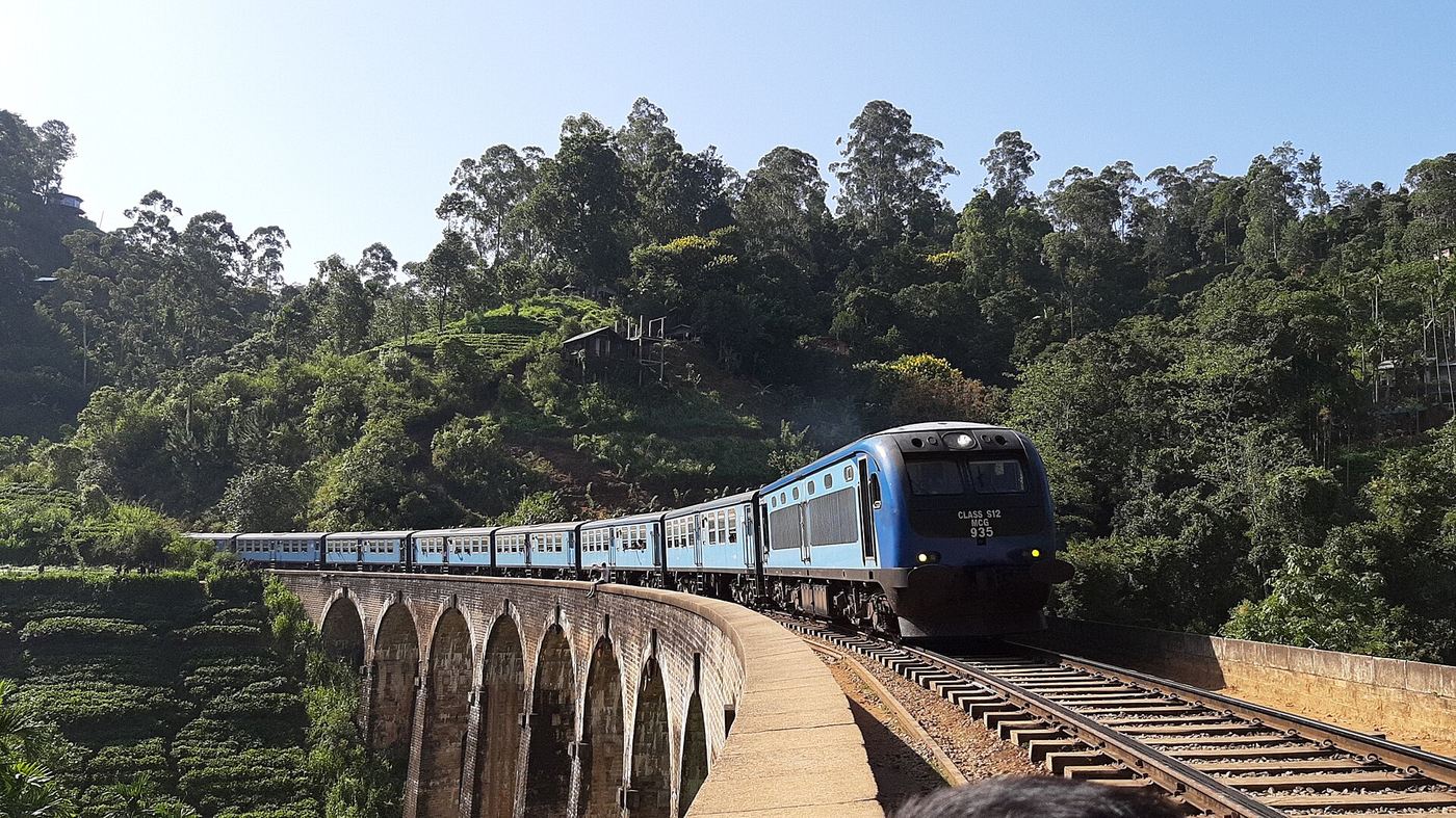 Blue train on a mountain railway bridge in Sri Lanka