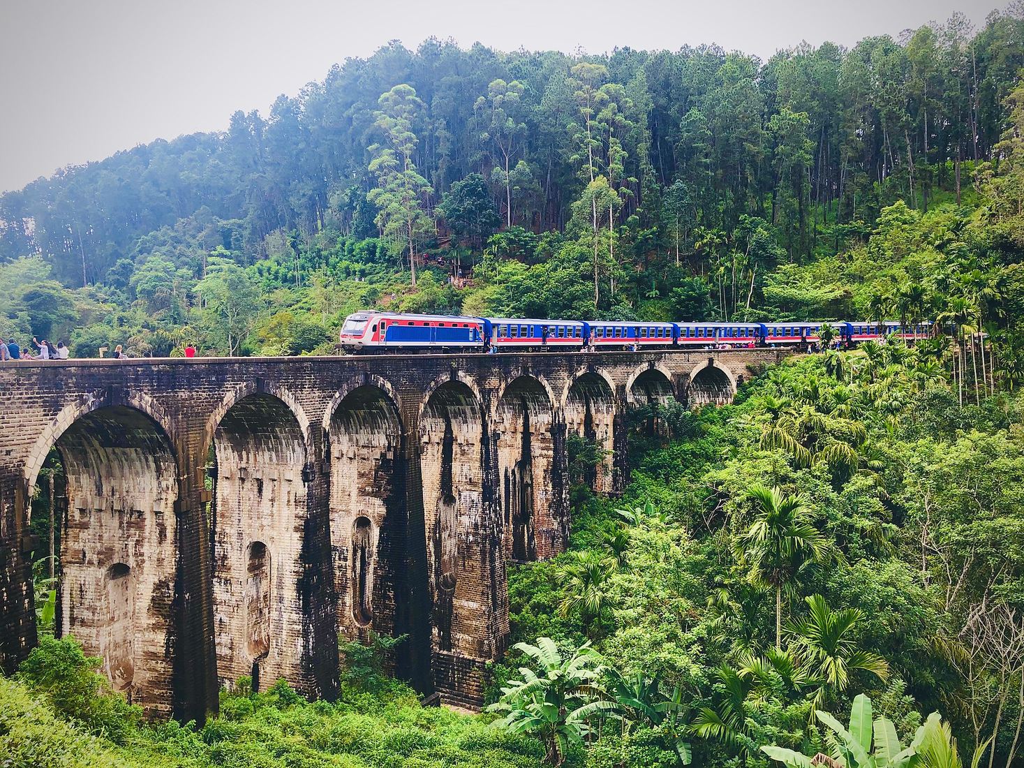 Blue train crossing Nine Arch Bridge near Ella